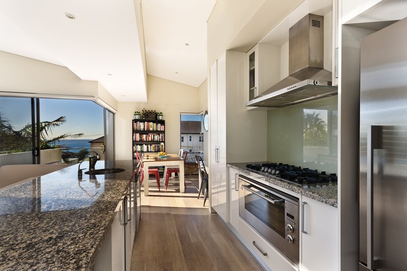 cocina moderna con piso estilo madera y barra de mármol